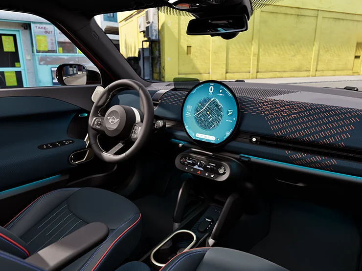 MINI interior with circular infotainment display showing navigation and digital driving information.