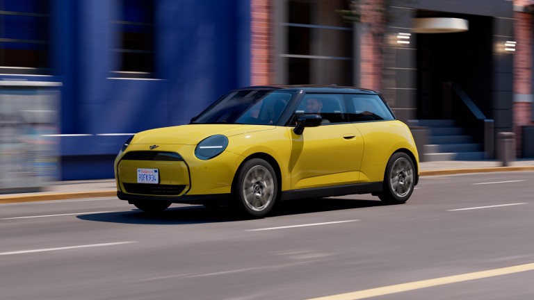Gulur rafknúinn MINI Cooper á ferð í borgarumhverfi